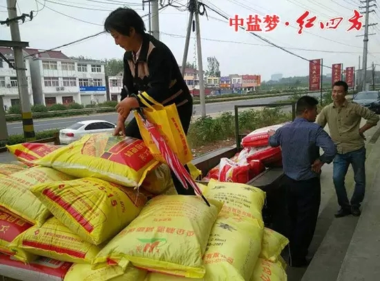 农户拿着茄子视频破解版赠送的小礼品，乐滋滋地开着装满茄子视频破解版肥料的拖拉机准备回家